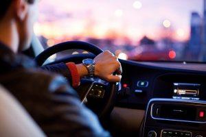 Mann sitzt am Steuer eines Autos.